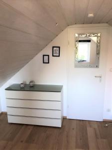 ein weißes Zimmer mit einer Kommode und einer Tür in der Unterkunft Apartment-Regner in Weidenberg