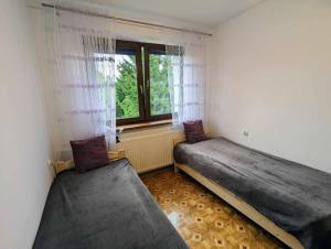 2 Betten in einem Zimmer mit Fenster in der Unterkunft Guest House close to Molo Resort in Osiek