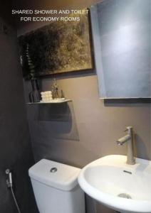 Łazienka z białą toaletą i umywalką w obiekcie VG Pension & Residences w mieście Adlawon