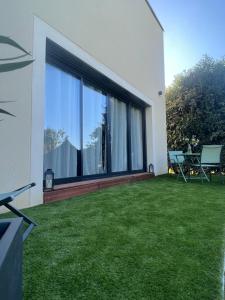 a backyard with a large window and green grass at Suite romantique avec Spa et filet suspendu in Auteuil
