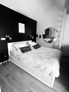 a bedroom with a white bed and a mirror at Suite romantique avec Spa et filet suspendu in Auteuil
