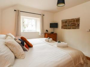 um quarto com uma grande cama branca e uma janela em Fenns Barn em Leek