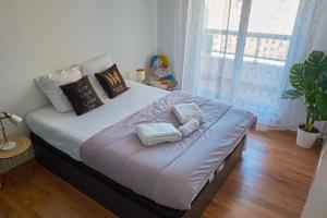 ein Bett mit Kissen darauf im Schlafzimmer in der Unterkunft Appartement cosy proche Paris et Stade de France in Saint-Denis