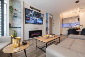 un soggiorno con divano e TV a parete di Apartment B - Lifestyle Holiday a Sveti Konstantin i Elena