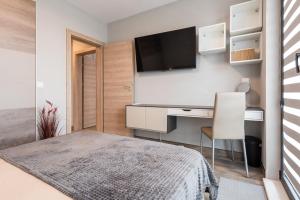 una camera con letto, scrivania e TV di Apartment B - Lifestyle Holiday a Sveti Konstantin i Elena