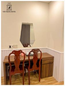 a dressing table with two chairs and a mirror at Vân Trang Hotel in Vĩnh Long