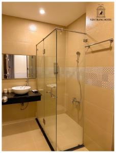 a bathroom with a glass shower and a sink at Vân Trang Hotel in Vĩnh Long