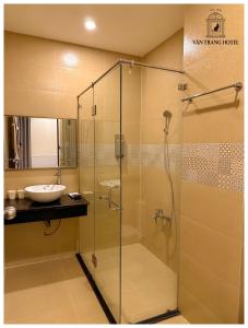 une salle de bain avec une douche en verre et un lavabo dans l'établissement Vân Trang Hotel, à Vĩnh Long