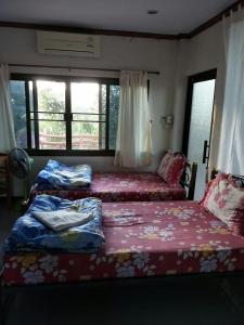 a bedroom with two beds and a window at ศรีวิภา​ฮิลล์​ in Khao Kho