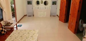 einen Flur mit weißen Türen und Fliesenboden in der Unterkunft ศรีวิภา​ฮิลล์​ in Khao Kho