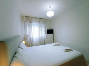 um quarto branco com uma cama e uma janela em Live Candelaria Alsaca con Balcón y Vista al Mar em Candelaria