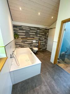 a large bathroom with a tub and a sink at Traumferienhaus Leimbach am Nürburgring in Leimbach