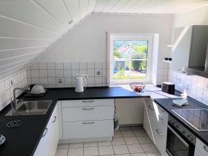 a kitchen with a black counter top and a window at Apartment-Regner in Weidenberg