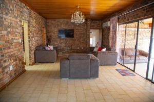 a living room with couches and a brick wall at Sojourners' Rest House in Germiston