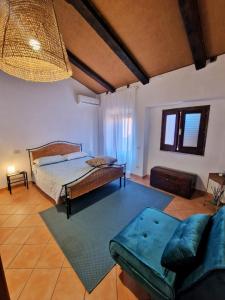 um quarto com uma cama e um sofá em LA CASETTA AZZURRA CHIANALEA - locazione turistica em Scilla