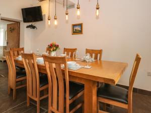 a dining room with a wooden table and chairs at Foggs Barn in Leek