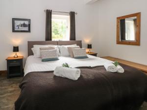 a bedroom with a large bed with towels on it at Foggs Barn in Leek