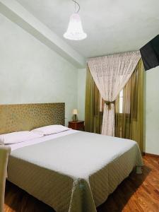 - une chambre avec un grand lit et une fenêtre dans l'établissement Le Boccede Country House B&B, à Villa Minozzo