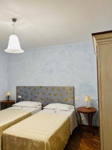 - une chambre avec 2 lits et un mur bleu dans l'établissement Le Boccede Country House B&B, à Villa Minozzo