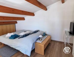 una piccola camera da letto con un letto e una TV di La Sirène - Loft moderne et lumineux avec vue panoramique sur Mer Méditerranée et port de plaisance a Frontignan