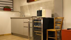 a microwave sitting on top of a refrigerator in a kitchen at LE TORRI Loft Apartment in Fossano +12 photos