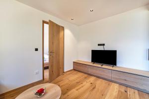 a living room with a flat screen tv on a wall at Huetterhof Apartement Langes in Caines