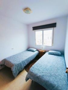 1 dormitorio con 2 camas y ventana en Adosado cerca de la playa, en Gran Alacant