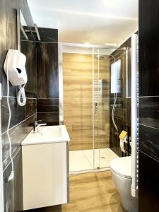 a bathroom with a shower and a sink and a toilet at LE TORRI Loft Apartment in Fossano