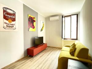 a living room with a couch and a television at LE TORRI Loft Apartment in Fossano