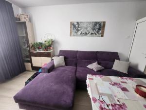 a living room with a purple couch and a table at Modern apartment. Best location in Sofia