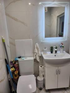 a bathroom with a white toilet and a sink at Modern apartment. Best location in Sofia