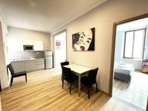 uma sala de estar com mesa e cadeiras e uma cozinha em LE TORRI Loft Apartment em Fossano