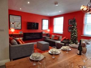 a living room with red walls and a christmas tree at My i360 Pad, close to Brighton seafront by Crown Gardens Holiday Homes in Brighton & Hove