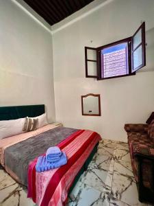 een slaapkamer met een bed en een raam bij Dar Ibrahim in Rabat