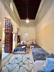 um quarto com duas camas e uma porta em Dar Ibrahim em Rabat