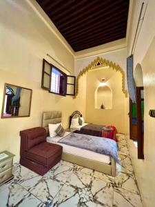 um quarto com uma cama e uma cadeira em Dar Ibrahim em Rabat