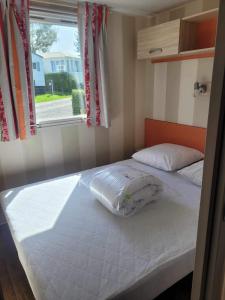 Säng eller sängar i ett rum på Location Mobil home 4/6 personnes camping avec piscine 1,5km de la plage Saint-Pair-sur-Mer en Basse Normandie (Sud manche) 35km du Mont saint-Michel