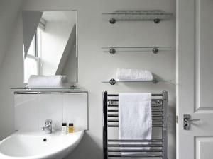 a white bathroom with a sink and a mirror at My i360 Pad, close to Brighton seafront by Crown Gardens Holiday Homes in Brighton & Hove
