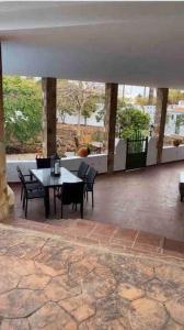 un patio con mesa y sillas en un edificio en La Finca. Casa en ciudad. Zona residencial muy tranquila, en Telde