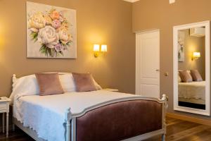 a bedroom with a bed with a flower painting on the wall at The Corner House in Hunedoara