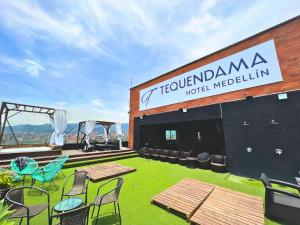 a building with chairs and tables and a sign on it at Tequendama Hotel Medellín - Estadio in Medellín