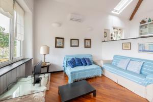een woonkamer met een blauwe bank en een tv bij [Terrazza sul mare] B.View56 in Recco