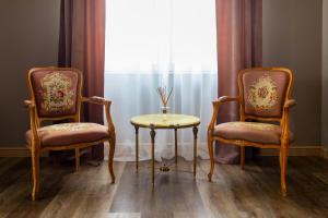 two chairs and a table in a room with a window at The Corner House in Hunedoara