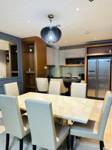 a kitchen with a large wooden table and chairs at Anggun Residence KL by F&F in Kuala Lumpur