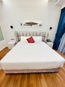 1 dormitorio con 1 cama blanca grande con almohadas rojas en Anggun Residence KL by F&F en Kuala Lumpur