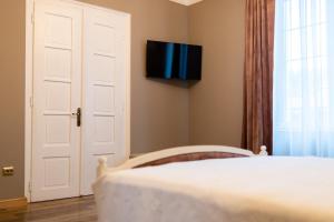 a bedroom with a bed and a tv on the wall at The Corner House in Hunedoara +28 photos