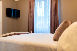 a bedroom with a bed with a large window at The Corner House in Hunedoara