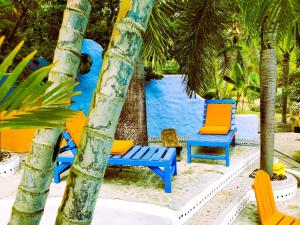 un grupo de sillas y palmeras en una playa en Reef View Pavilions - Villas & Condos en Lance aux Épines