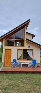 een huis met twee blauwe stoelen op een terras bij cabaña La Ufu 2 in Las Golondrinas