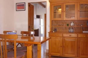 a kitchen with a table and a wooden cabinet at Finca Roja Formentera in Sant Francesc Xavier
